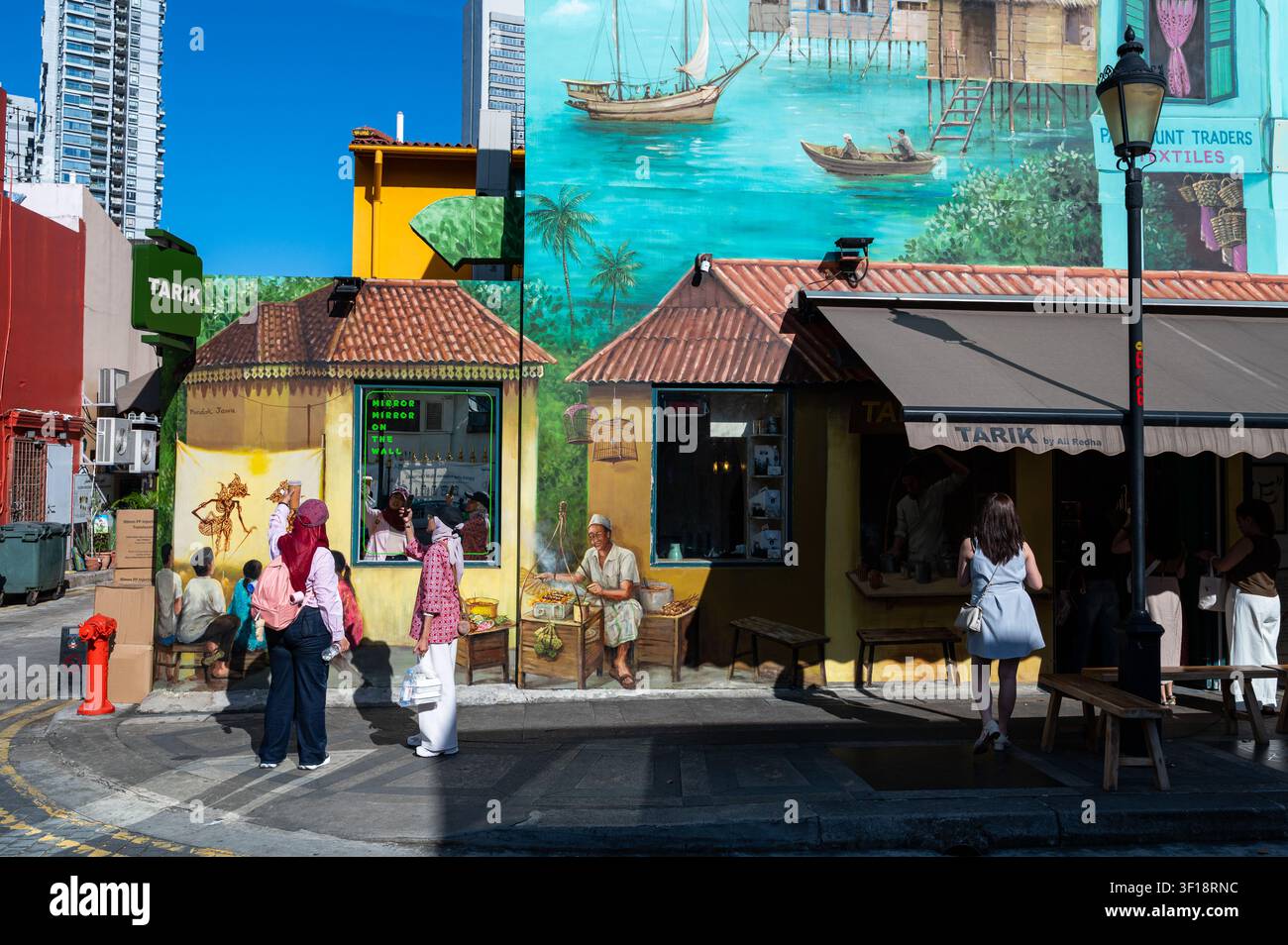 27.06.2026, Singapour, République de Singapour, Asie – Scène de rue avec des personnes devant une fresque artistique de rue colorée sur un bâtiment le long de Muscat Street. Banque D'Images
