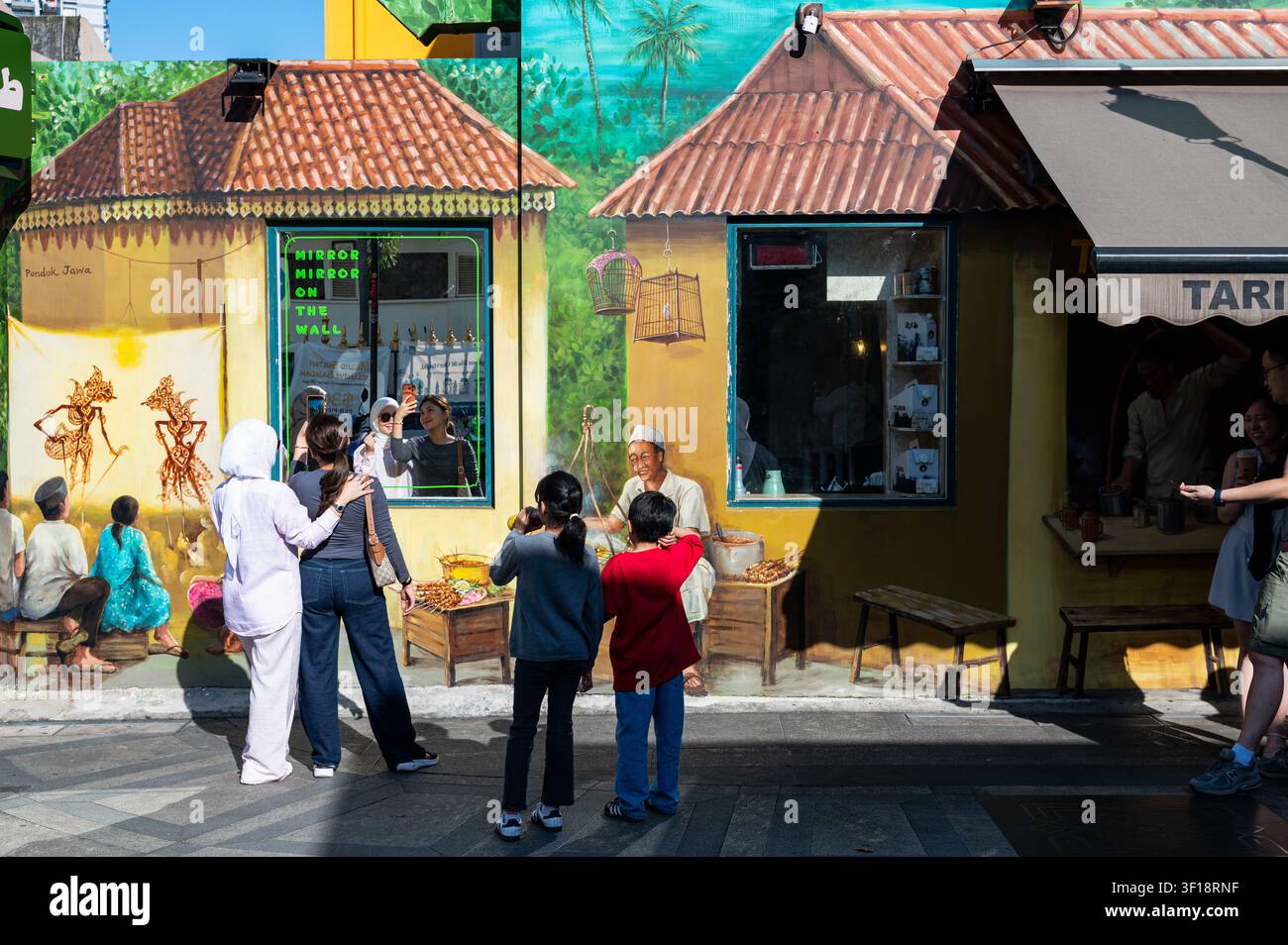 27.06.2026, Singapour, République de Singapour, Asie – Scène de rue avec des personnes devant une fresque artistique de rue colorée sur un bâtiment le long de Muscat Street. Banque D'Images