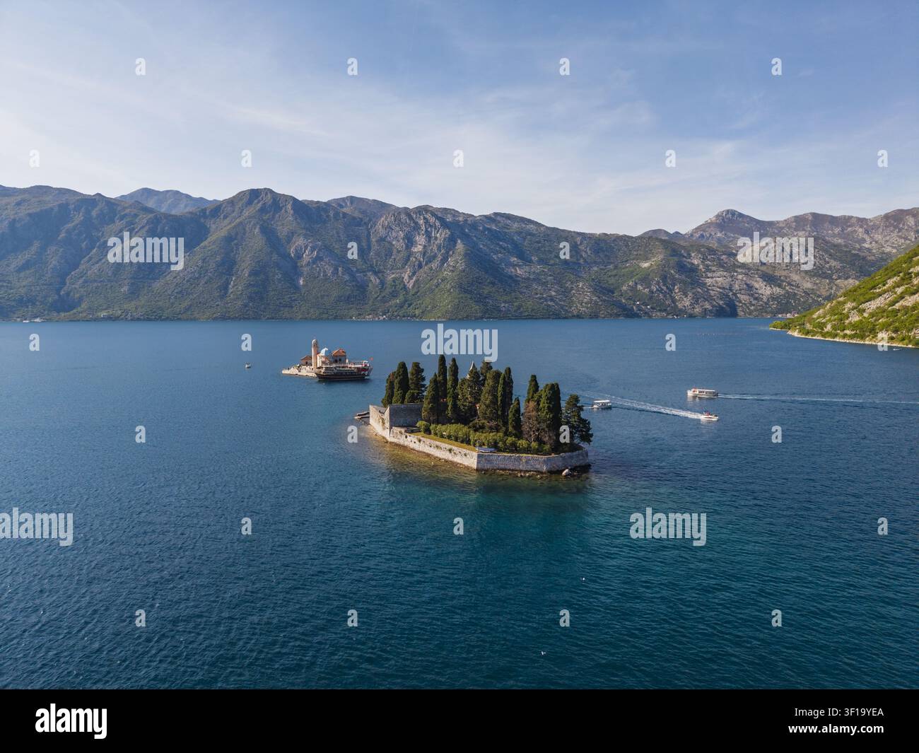 Vue aérienne de Notre-Dame des Rochers et des îles Saint-Georges dans la baie de Kotor, avec une eau bleue, des montagnes et des bateaux à Perast, municipalité de Kotor Banque D'Images