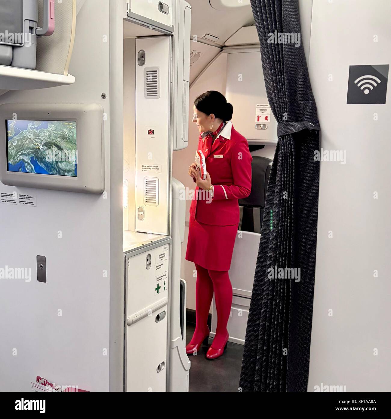 Une hôtesse de l'air d'Austrian Airlines accueille les passagers à bord. Banque D'Images