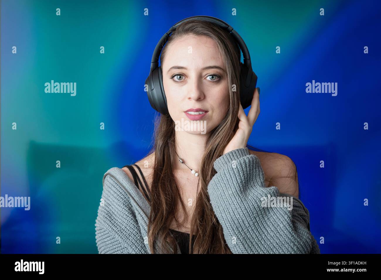 Jeune femme concentrée profitant d'un audio immersif grâce à des écouteurs sans fil Banque D'Images