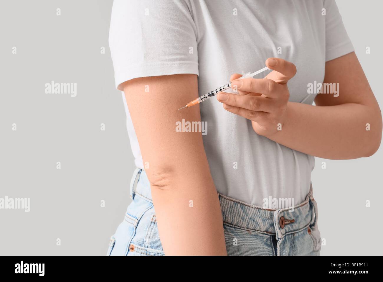 Femme s'injectant un médicament dans le bras avec une seringue, traitement médical et soins de santé Banque D'Images