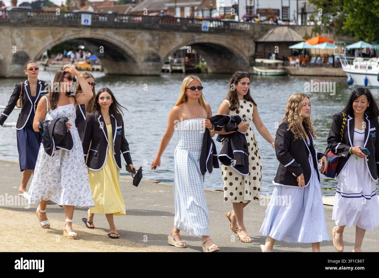 Jeunes femmes marchant le long de la Tamise dans des blazers d'aviron assortis lors du Henley Royal Regatta Banque D'Images