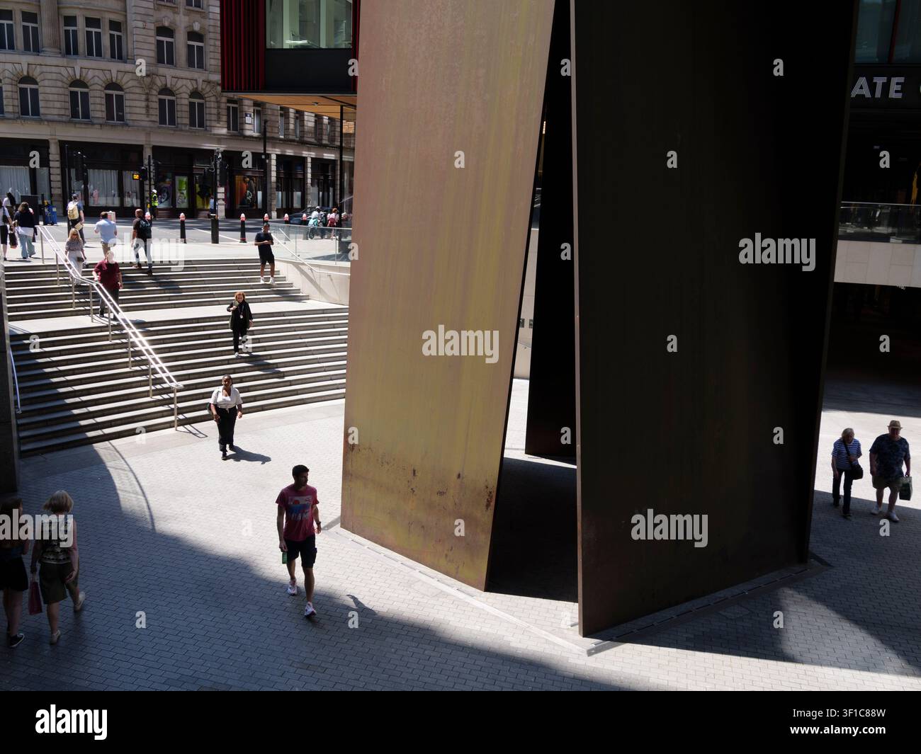 Des acheteurs et des navetteurs descendent une large volée d'escaliers extérieurs menant aux places d'entreprises modernes du domaine de Broadgate dans la City de Londres, au Royaume-Uni, encadrés à droite par Fulcrum, une sculpture monumentale en tôle d'acier patiné spécifique au site de l'acclamé artiste contemporain américain Richard Serra Banque D'Images