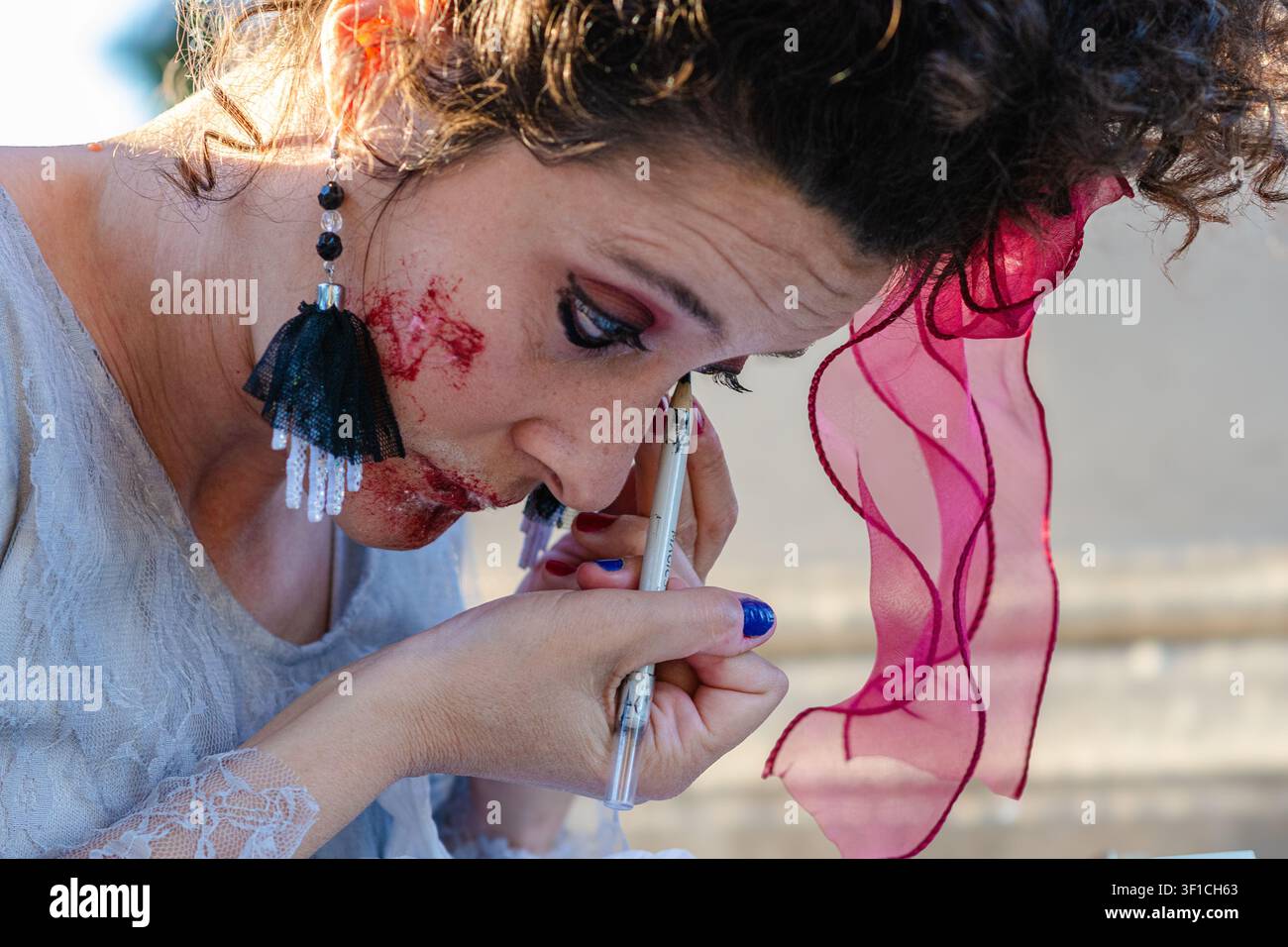 Femme appliquant du maquillage à effets spéciaux pour un costume d'Halloween Banque D'Images