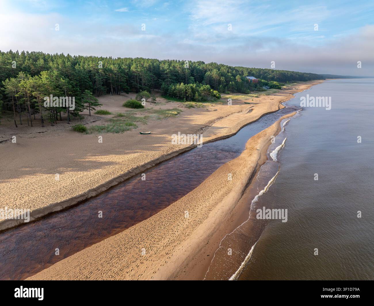Vue aérienne de l'estuaire de la rivière Peterupe rencontrant la mer Baltique au lever du soleil près de Saulkrasti, Lettonie Banque D'Images