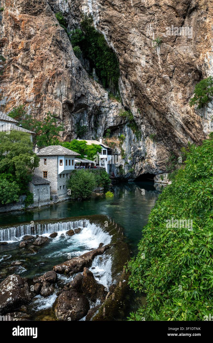 Maisons historiques en pierre au bord de l'eau à côté d'une grotte Banque D'Images
