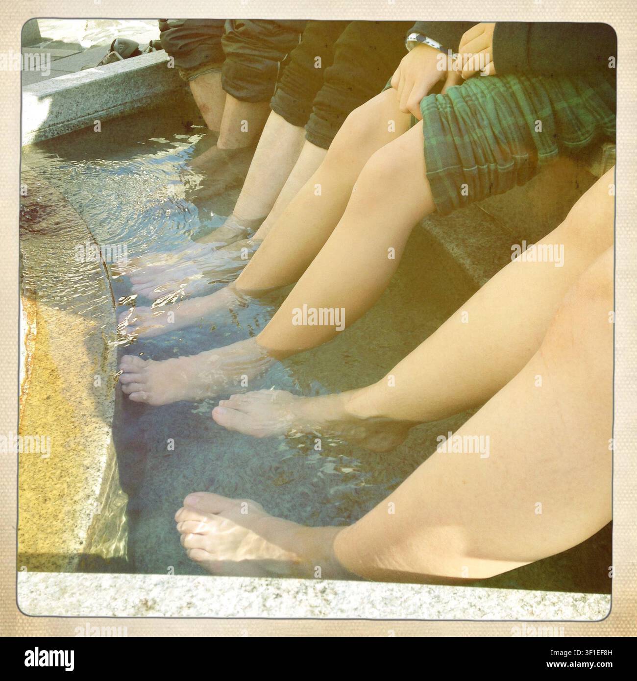 Les visiteurs trempent leurs pieds dans un spa pour les pieds à l'extérieur de la gare de Dogo Onsen près de Dogo Onsen, considérée comme la plus ancienne station thermale du Japon dans la ville de Matsuyama, préfecture d'Ehime, Japon. Photographe : Robert Gilhooly Banque D'Images