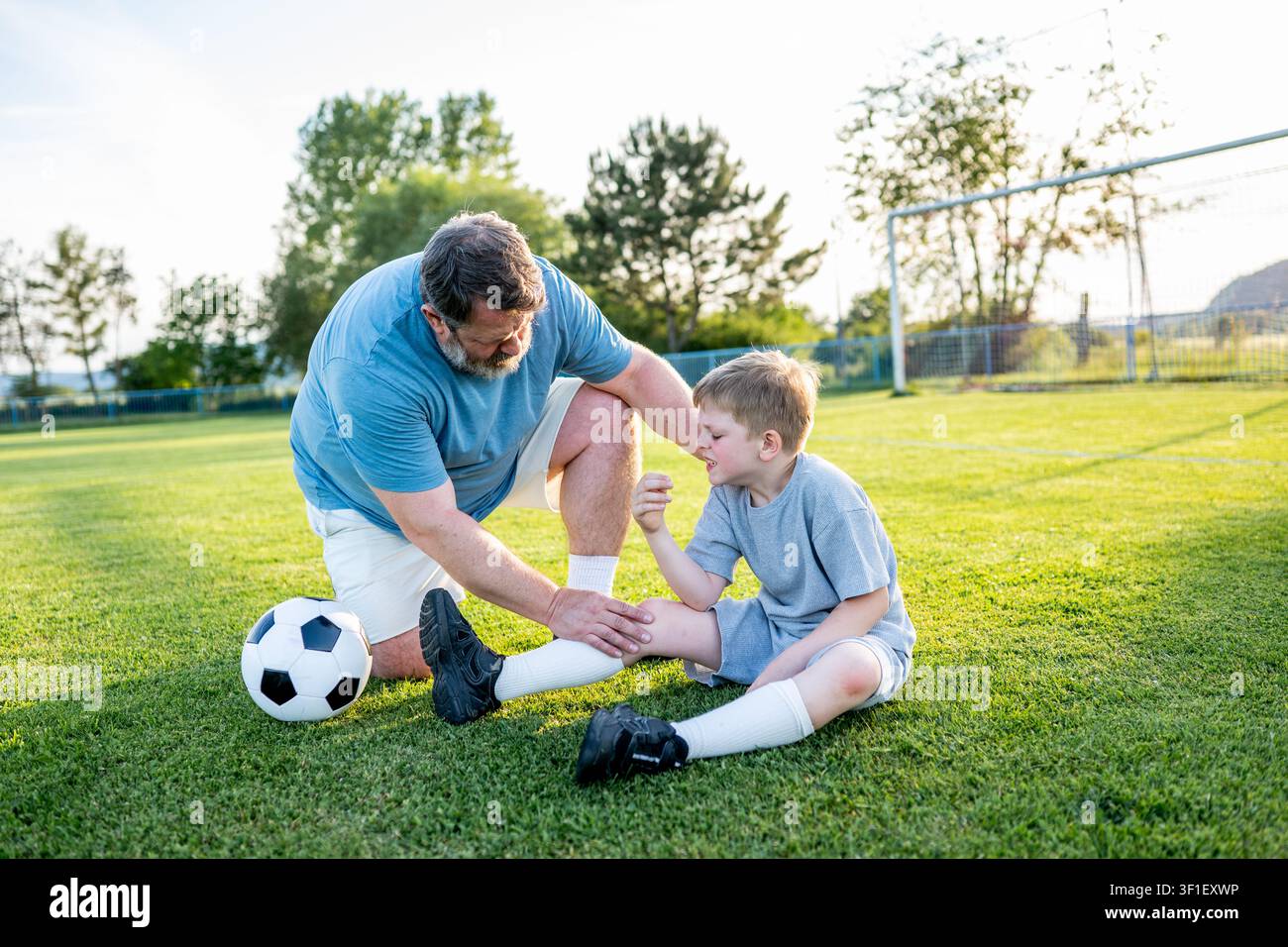 Garçon ayant un petit accident pendant l'entraînement de football. Banque D'Images