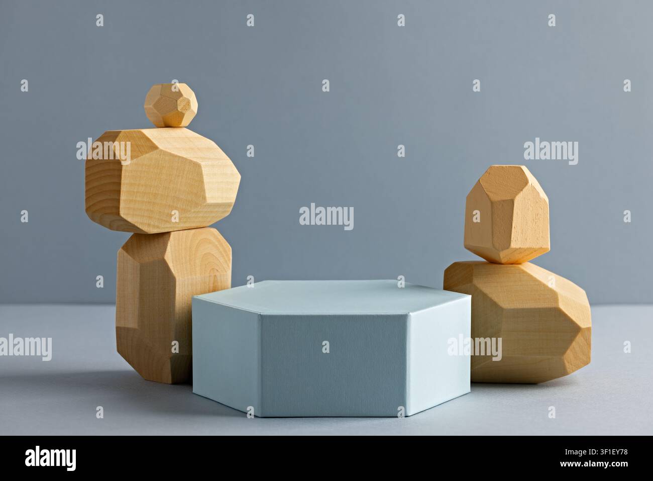 Sculptures en bois géométriques avec piédestal hexagonal sur fond minimaliste pour une décoration moderne Banque D'Images