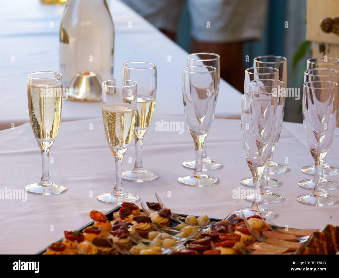 Flûtes à champagne et canapés savoureux arrangés pour une réception caterée Banque D'Images