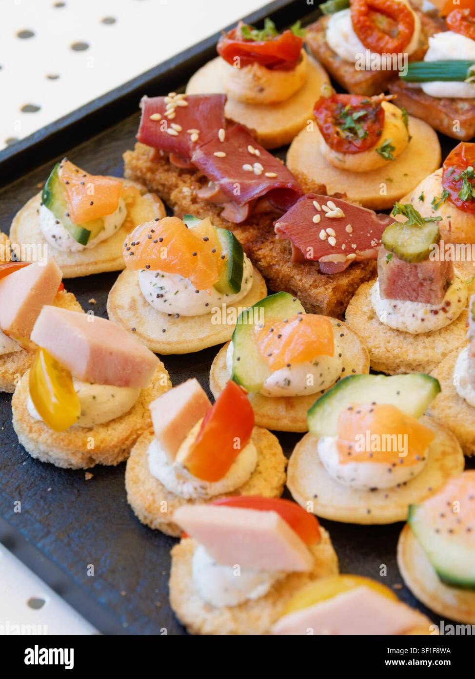 Canapés gourmands variés et amuse-gueules disposés sur un plateau de traiteur Banque D'Images