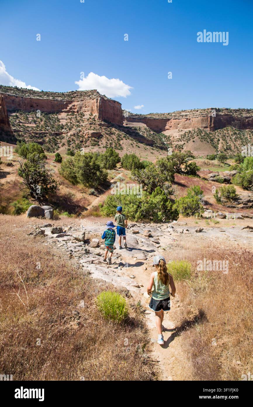 Trois enfants randonnant ensemble dans un canyon désertique Banque D'Images