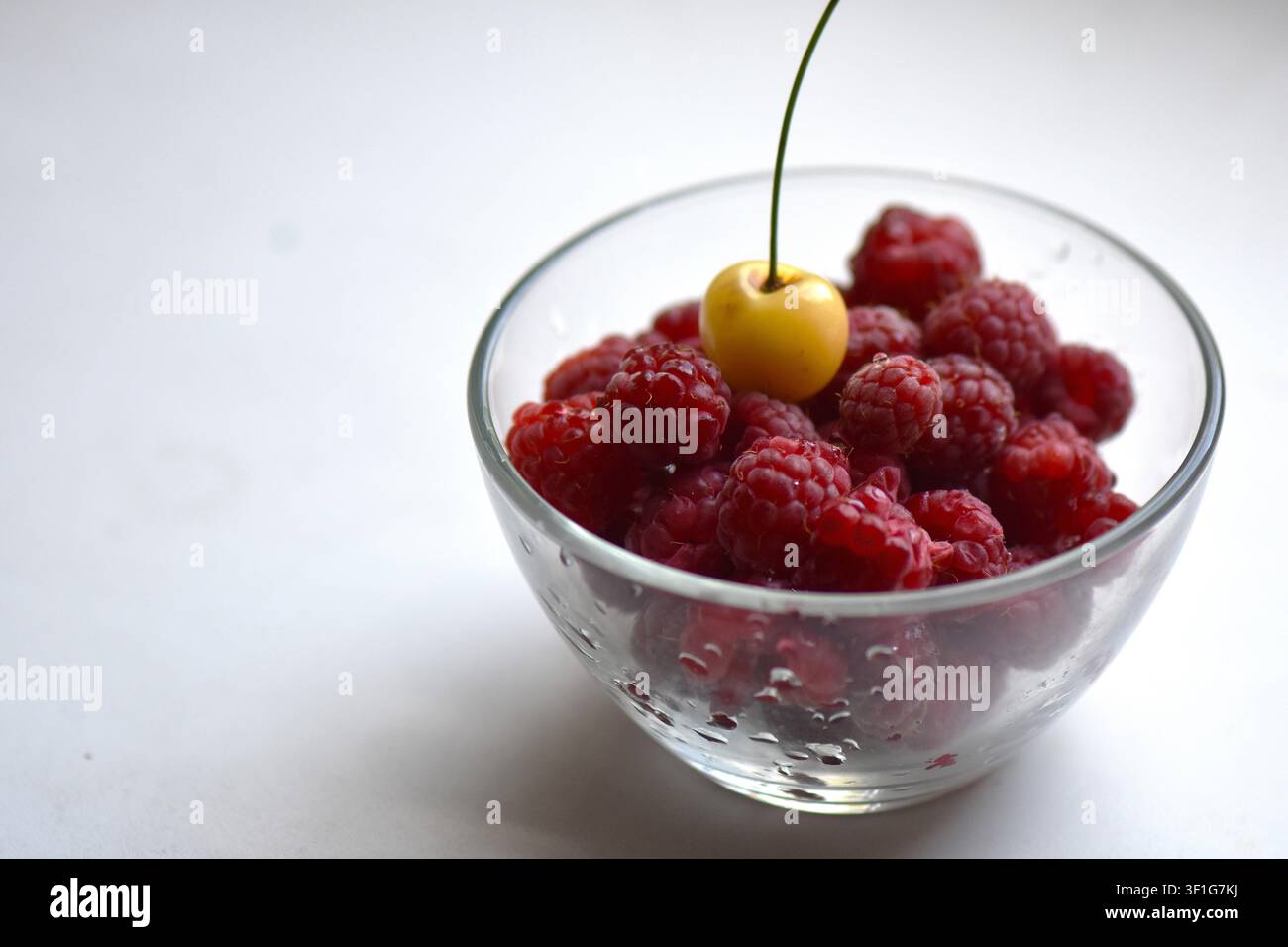 Cerise jaune au sommet des framboises rouges Banque D'Images