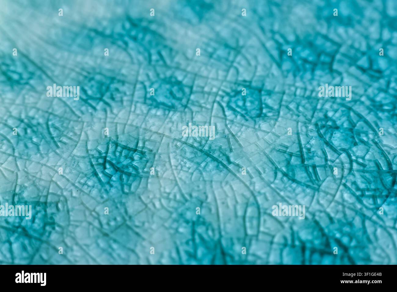 Une texture de glaçure céramique craquelée avec un motif craquelé bleu-vert, surface abstraite vieillie, détail de poterie vintage Banque D'Images