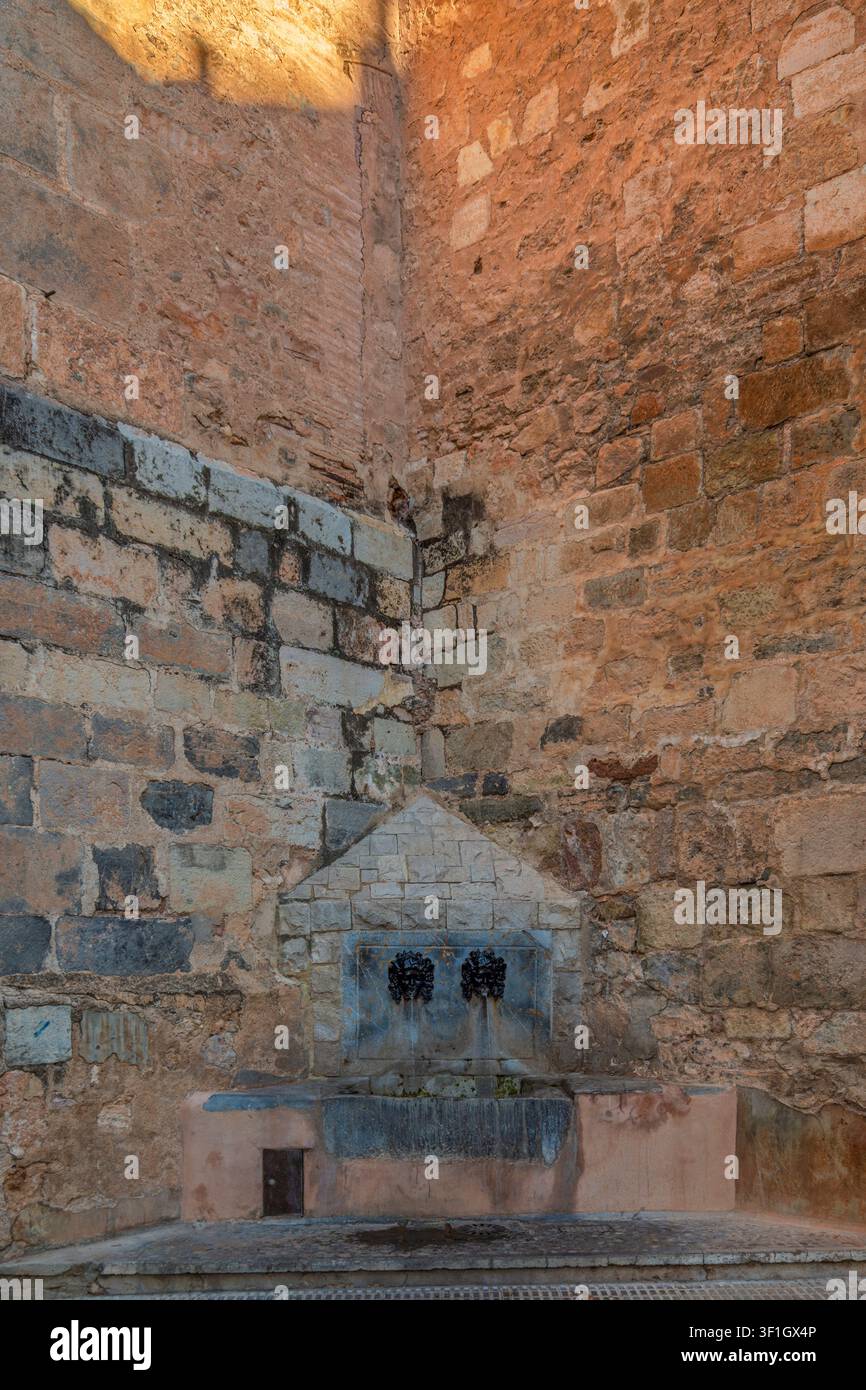Fontaine historique en pierre avec deux becs en forme de masques métalliques intégrés dans un mur de maçonnerie érodé à Onda, Castellon, Castello, Communauté valencienne, Espagne. UE. Banque D'Images