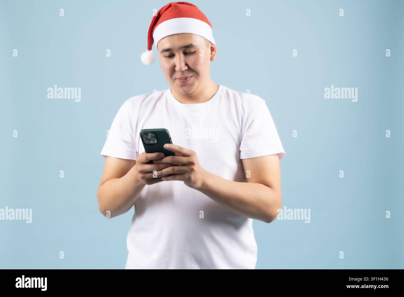 Jeune homme joyeux envoyant un message sur son smartphone portable Banque D'Images
