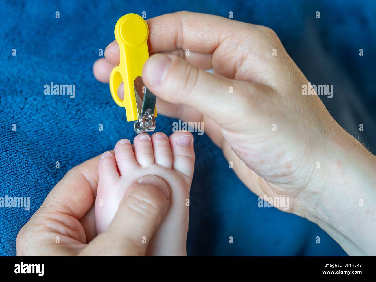 Coupe des ongles du bébé avec une pince à ongles sûre pour bébé pendant le soin du nourrisson à la maison Banque D'Images
