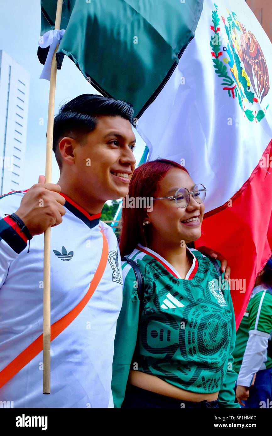 Mexico City, CDMX, Mexique – 5 juillet 2026 : Couple de fans de football posant avec le drapeau mexicain Banque D'Images