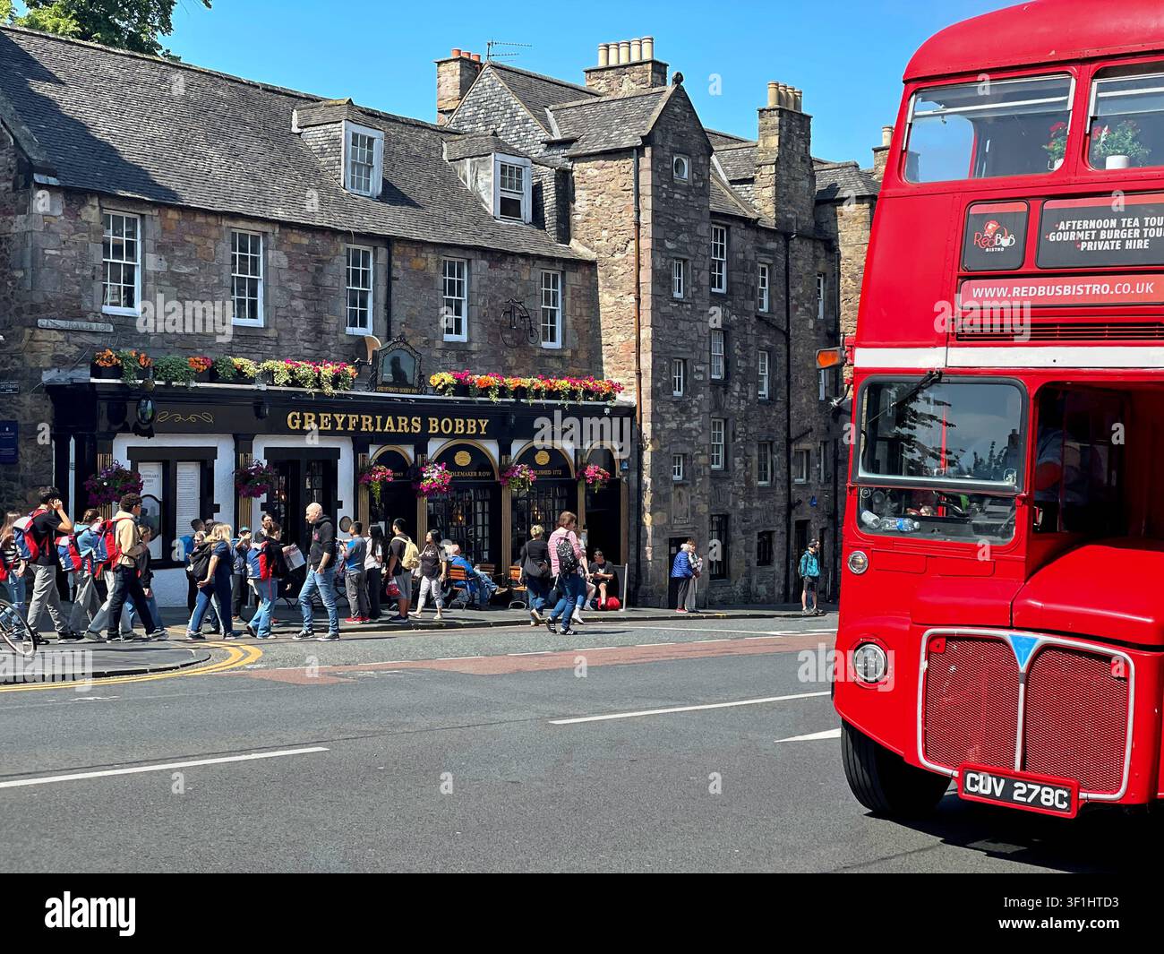 Bus rouge Routemaster sur le pont King George IV passant devant le pub Greyfriars Bobby, à Édimbourg, Écosse - Image de stock capturée avec un smartphone