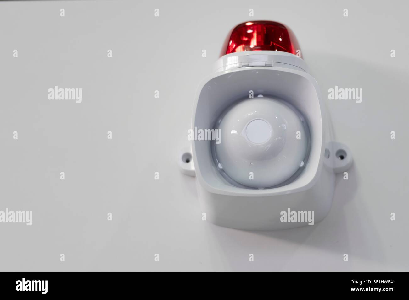 Sirène d'alarme murale blanche avec beacon d'avertissement rouge, gros plan d'équipement de signalisation de sécurité et d'urgence. Banque D'Images