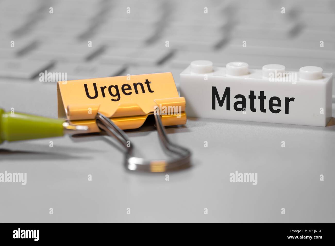 Pince à reliure et brique de jouet avec le texte « Urgent Matter » indiquant la priorité et l'importance Banque D'Images