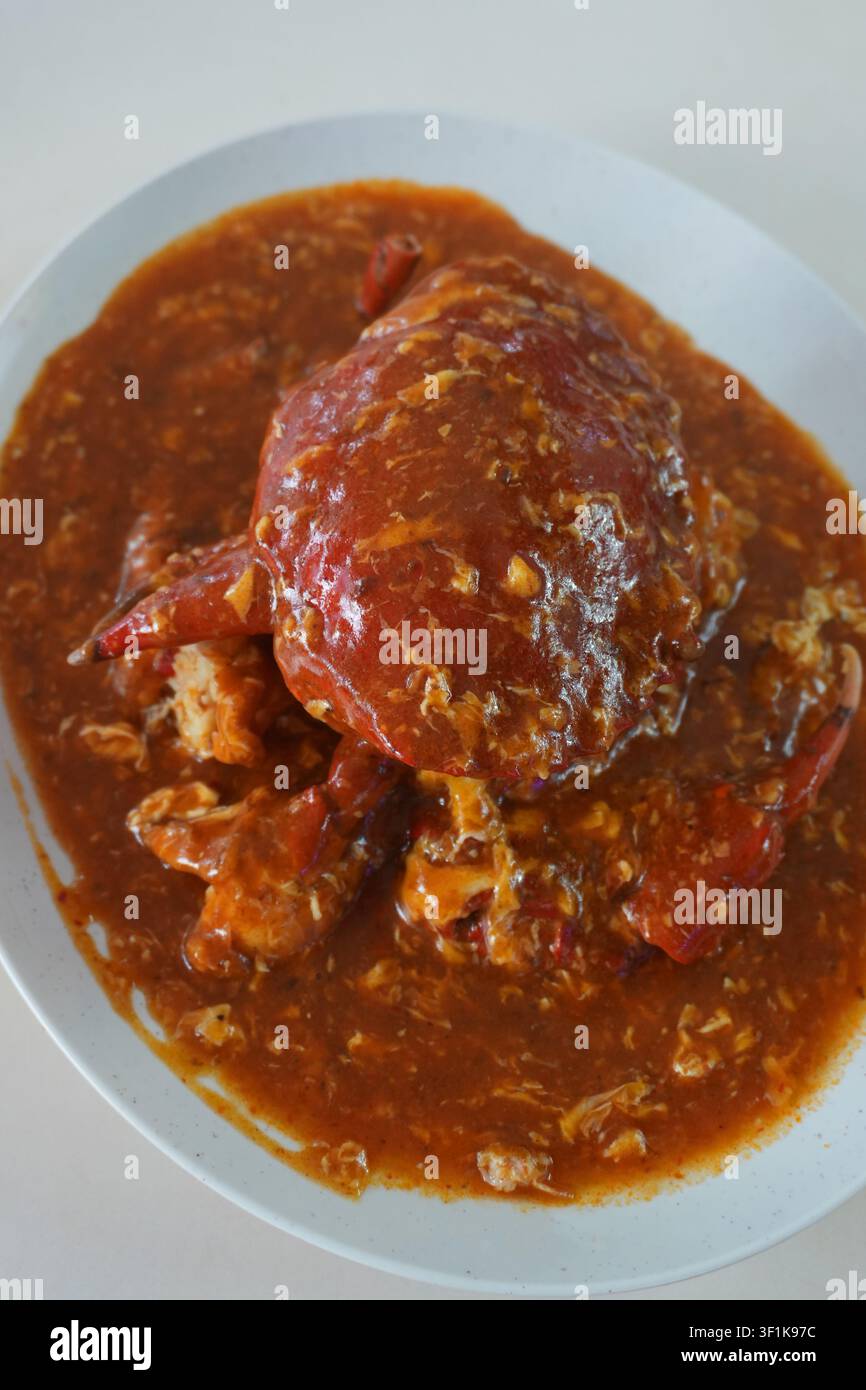 Grand crabe de mer recouvert d'une sauce au curry au piment rouge, plat classique épicé d'un restaurant thaïlandais Banque D'Images