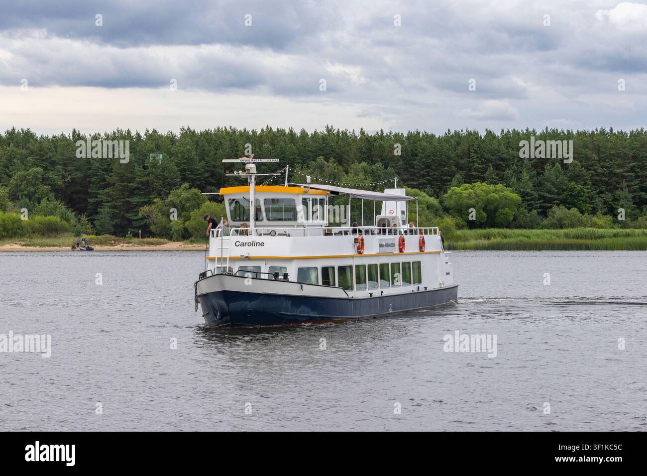 Un bateau de croisière fluviale approchant Narva-Jõesuu en Estonie. La rivière Narva est partagée entre l'Estonie et la Russie et l'arrière-plan montre des terres russes. Banque D'Images