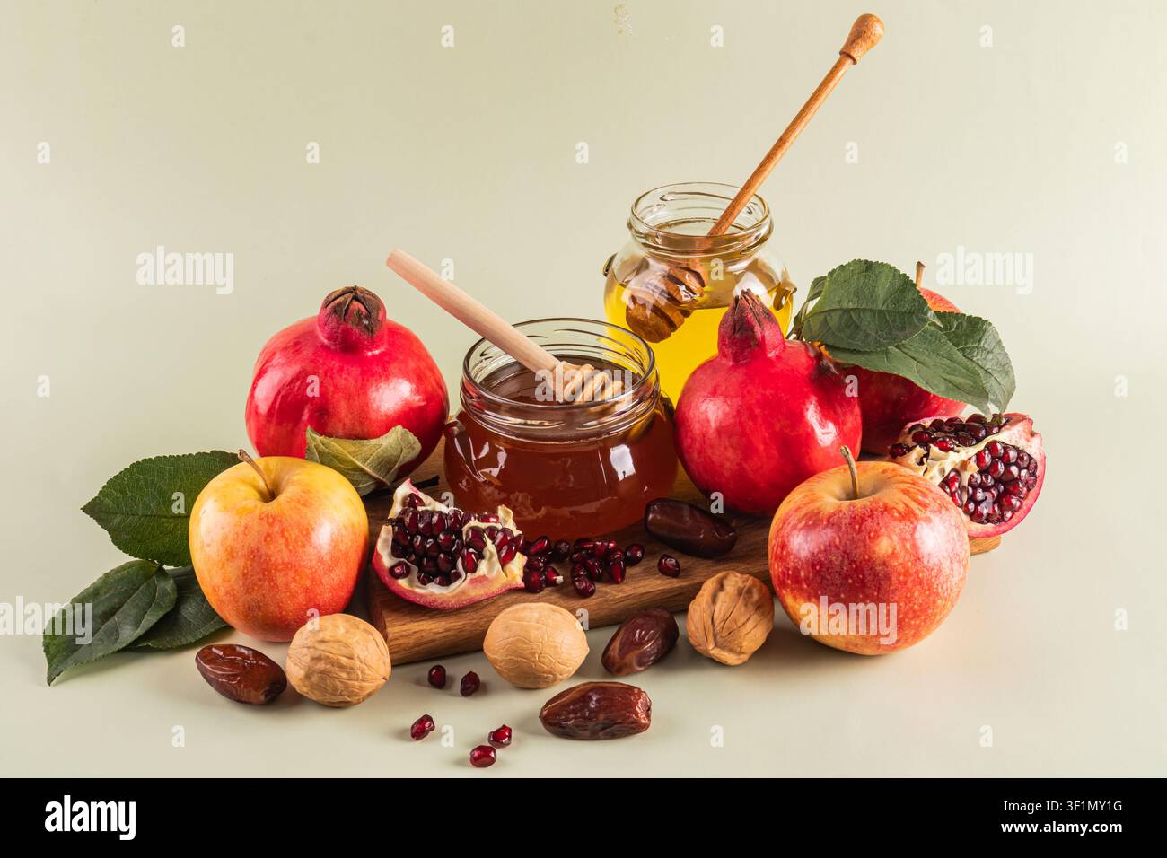 Une exposition vibrante de symboles traditionnels de Rosh Hashanah incluant des pommes, du miel, des grenades et des noix, signifiant l'espoir et la douceur pour le N juif Banque D'Images