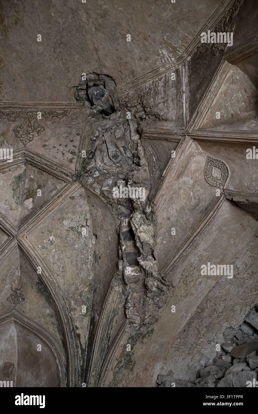 Plafond voûté endommagé avec plâtre fissuré et maçonnerie apparente dans les monuments historiques Banque D'Images