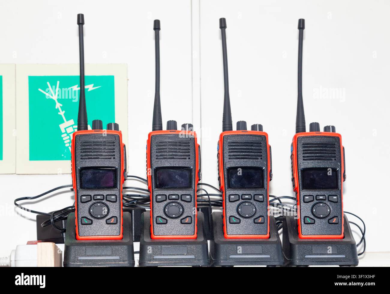 De nombreux talkies-walkies sont posés dans leurs chargeurs et se rechargent Banque D'Images