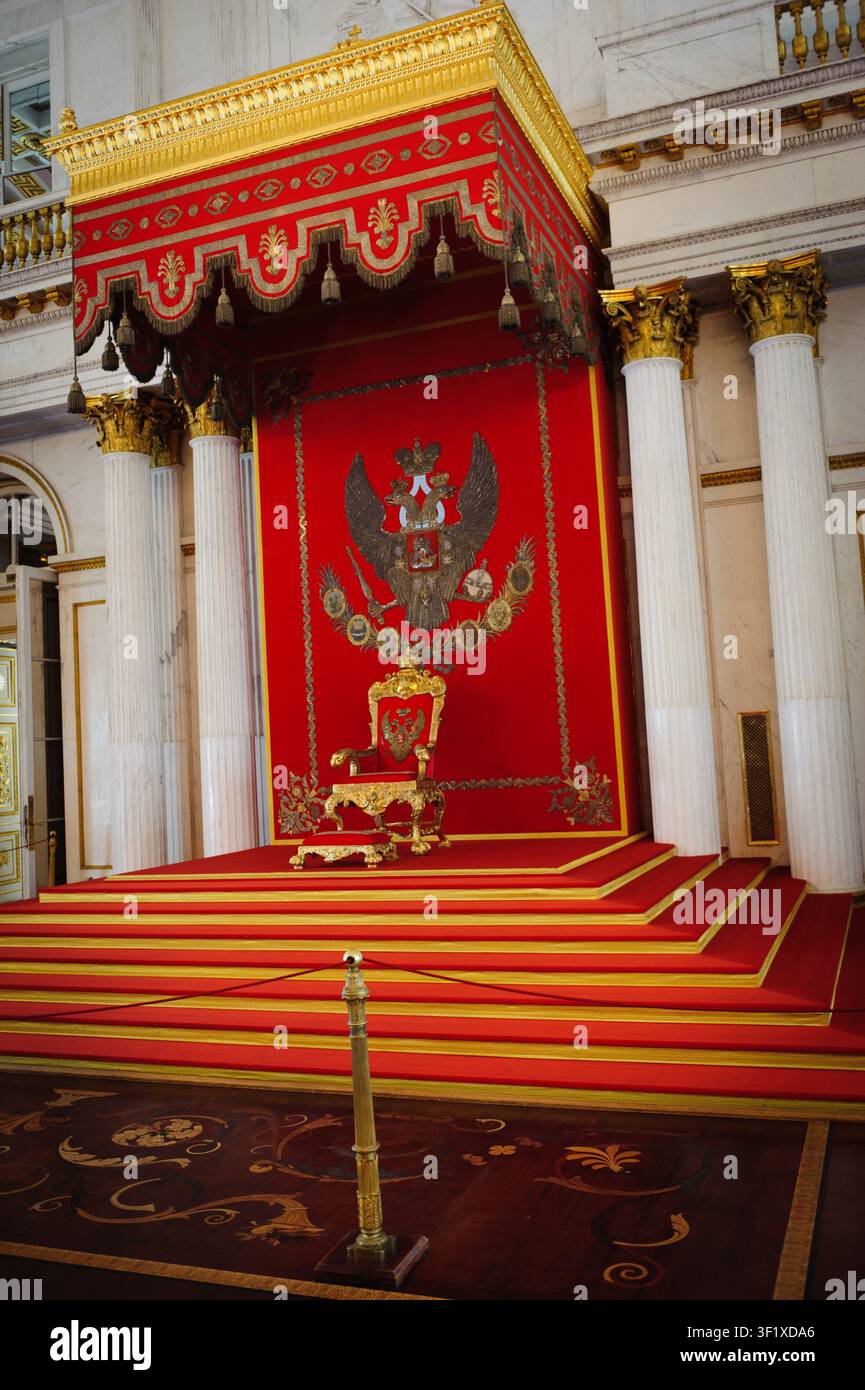 Une salle du trône royale avec un décor orné rouge et or mettant en vedette un emblème proéminent en arrière-plan. Banque D'Images