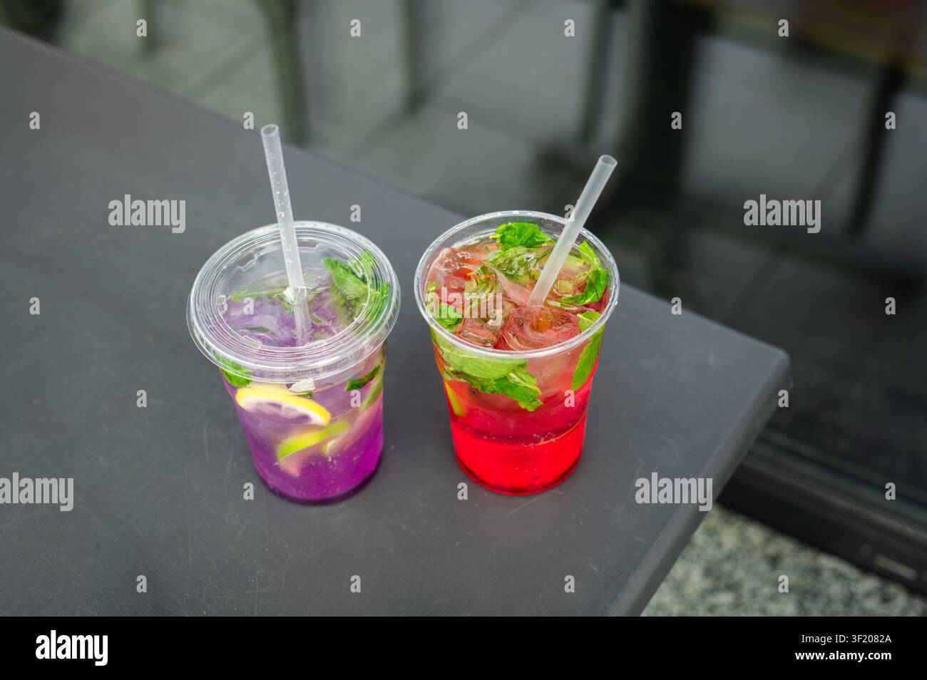 Limonades aux fruits faits maison avec des tranches d'agrumes, de la menthe et de la glace servies dans des gobelets à emporter. Boissons rafraîchissantes d'été. Banque D'Images