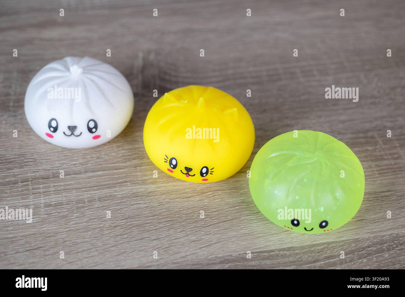 Ensemble de jouets en slime mignons kawaii aux visages souriants sur fond en bois Banque D'Images