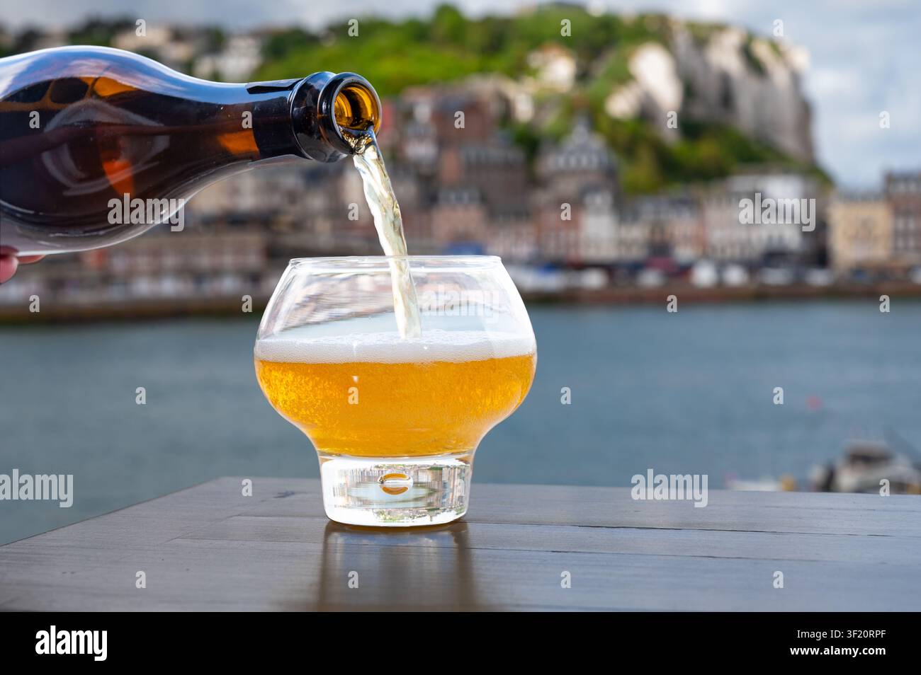 Cidre de pomme de Normandie versé avec vue sur le Tréport avec de superbes falaises de craie dorées, boisson pétillante aux pommes, goût rafraîchissant. Sur fond pictu Banque D'Images