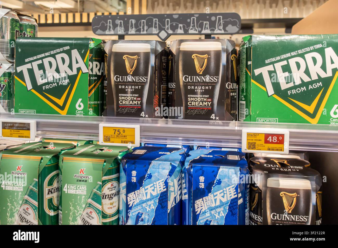 Étagère du supermarché Wellcome présentant des packs de Guinness Draught Stout I en configurations de 4 canettes, des packs de bière Terra et de la bière en conserve Kingway. Hong Kong Banque D'Images