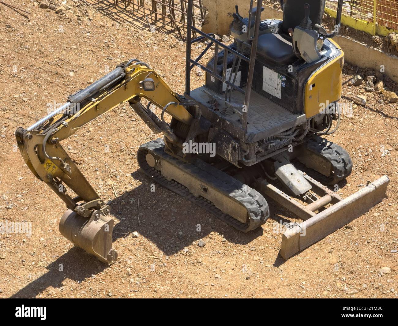 Vue d'une mini-excavatrice jaune garée sur un chantier de construction en terre à Istanbul, Istanbul, Turkiye. Banque D'Images