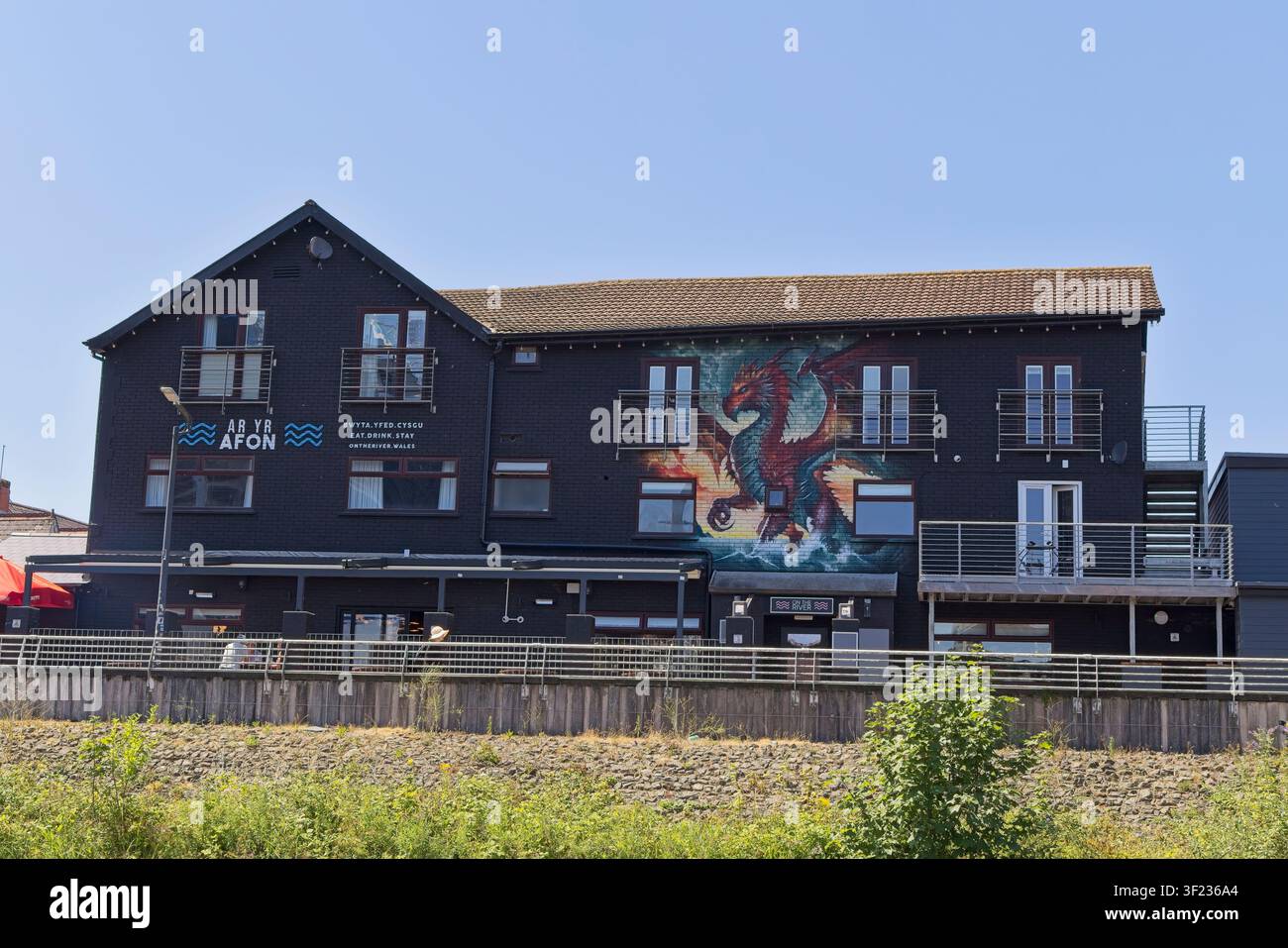 L’extérieur du bar et grill Ar Yr Afon avec une grande fresque murale du dragon gallois le long du front de mer de Cardiff Bay, Pays de Galles, Royaume-Uni. Banque D'Images