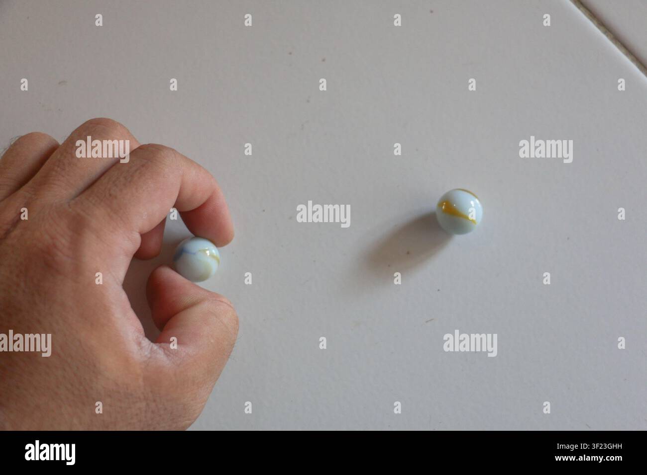 Main tenant une boule en verre avec une autre boule au loin, concept de choix et de prise de décision, composition créative minimale Banque D'Images