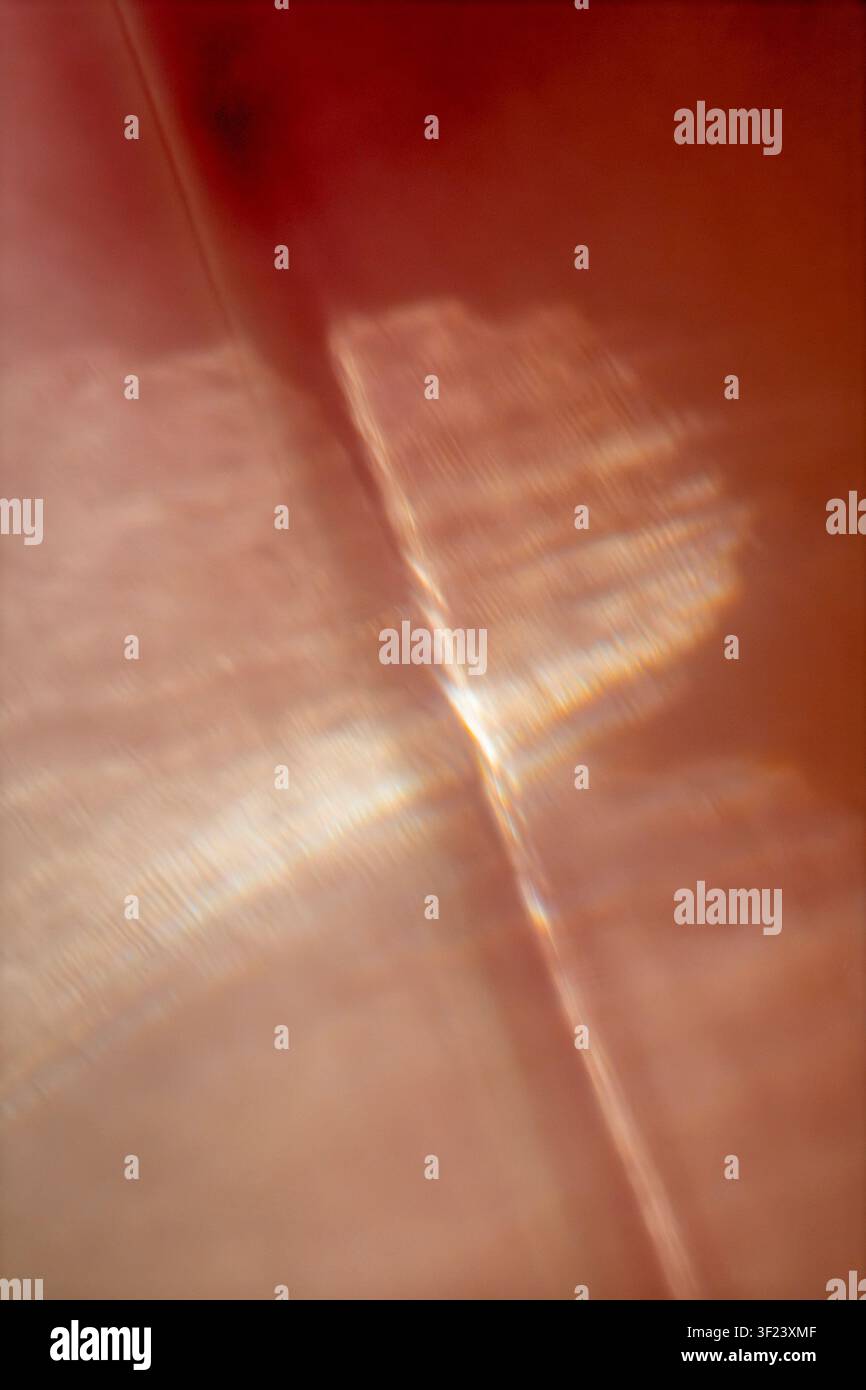 Réfraction de lumière chaude abstraite avec des réflexions géométriques douces dans des tons ambré, pêche et crème. Banque D'Images