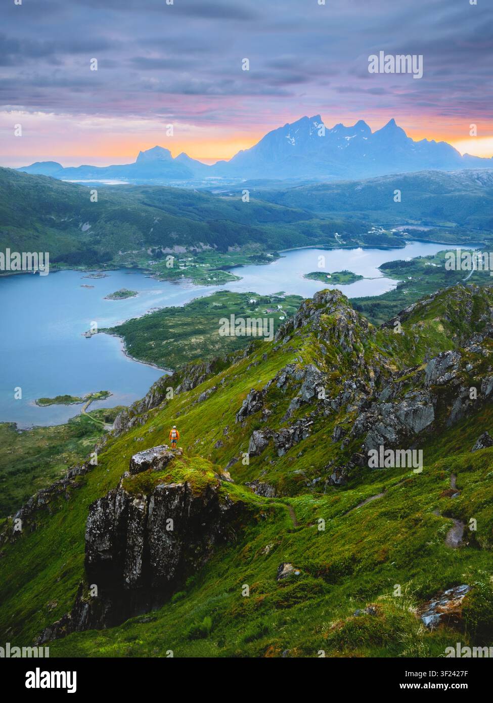 Vue aérienne des îles Lofoten et un homme randonneur debout seul sur une falaise dans les montagnes, voyage en Norvège, aventure vacances d'été tour en plein air magnifique Banque D'Images