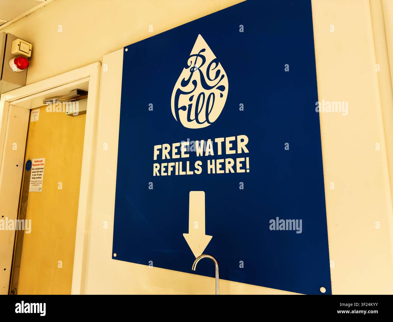 Un panneau directionnel bleu indique une station de remplissage d'eau gratuite à l'intérieur d'un bâtiment public à Manchester Banque D'Images