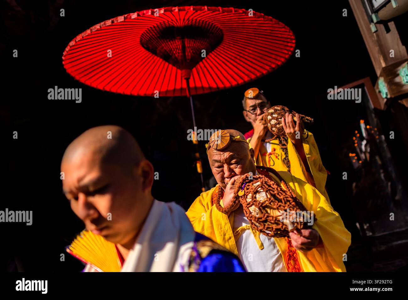 Les moines Yamabushi soufflent dans des horagai, des trompettes en coquillage, lors de la cérémonie de marche sur le feu au temple Daisho-in sur l'île de Miyajima, au Japon. Banque D'Images