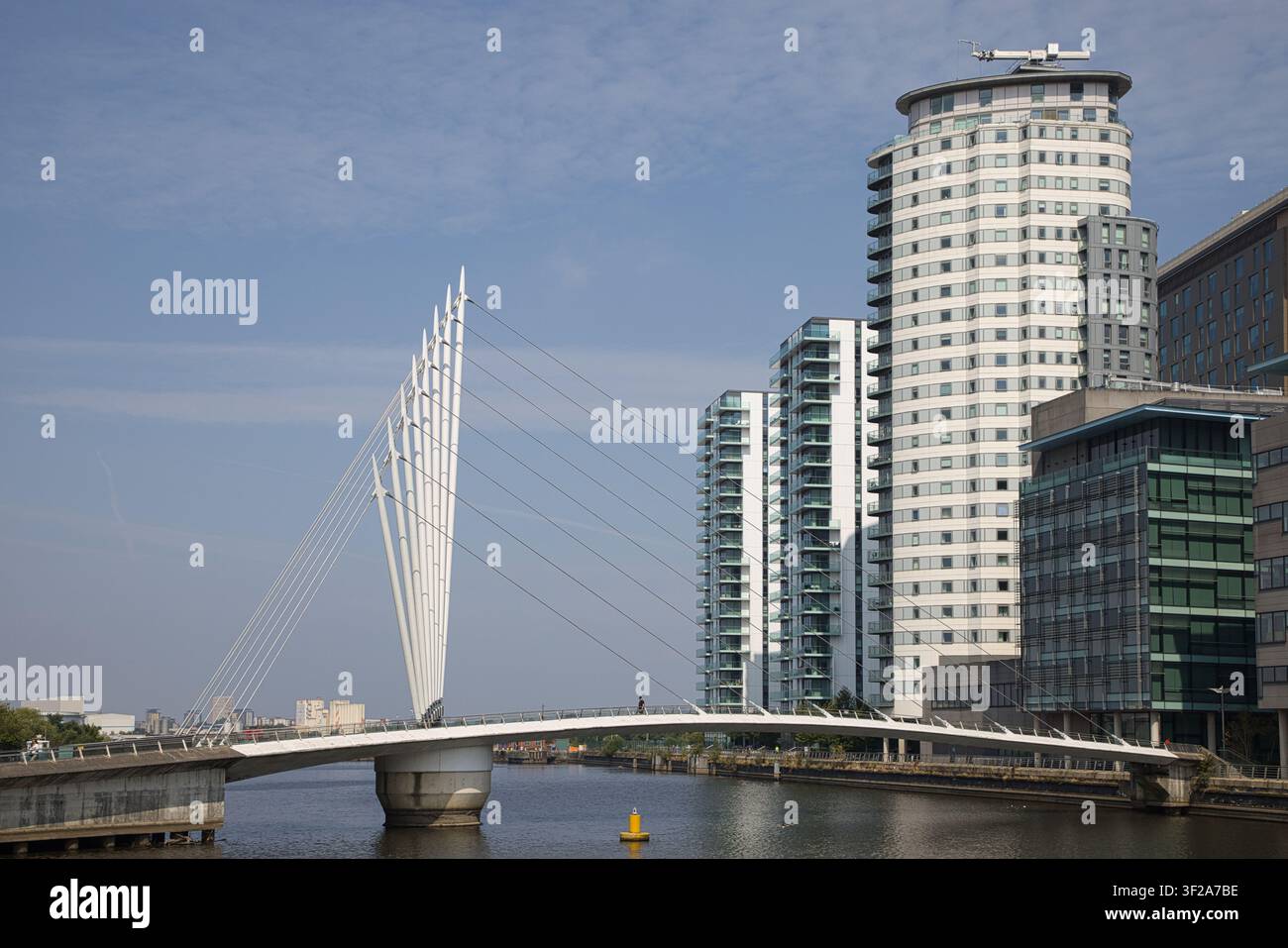 Passereille MediaCityUK enjambant les eaux du canal à Salford Quays, avec une personne solitaire non identifiable traversant, Salford, Manchester, Royaume-Uni. Banque D'Images