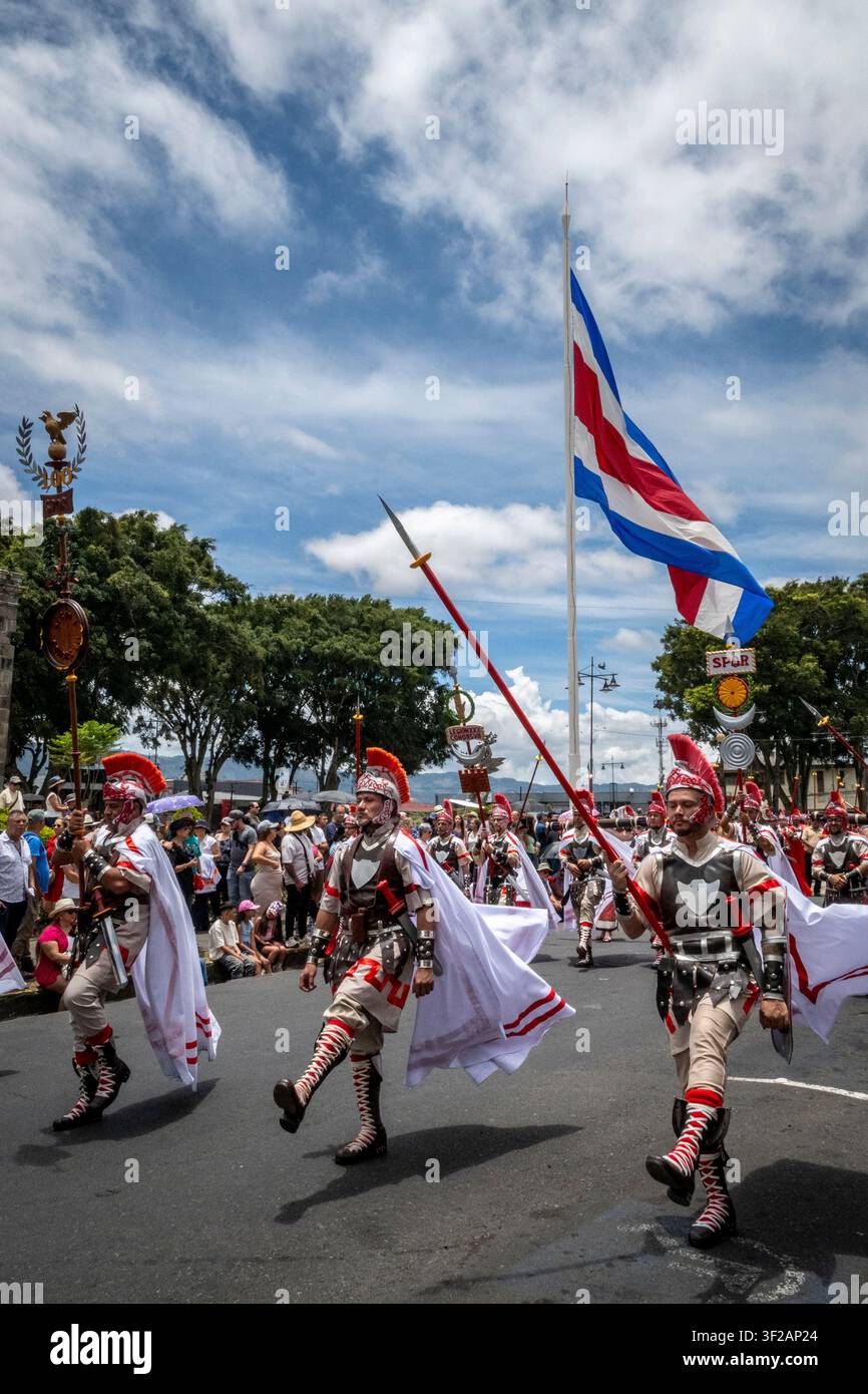 Des hommes en costume défilent devant un drapeau costaricain lors d'une procession de la Semaine Sainte à Cartago, Costa Rica Banque D'Images