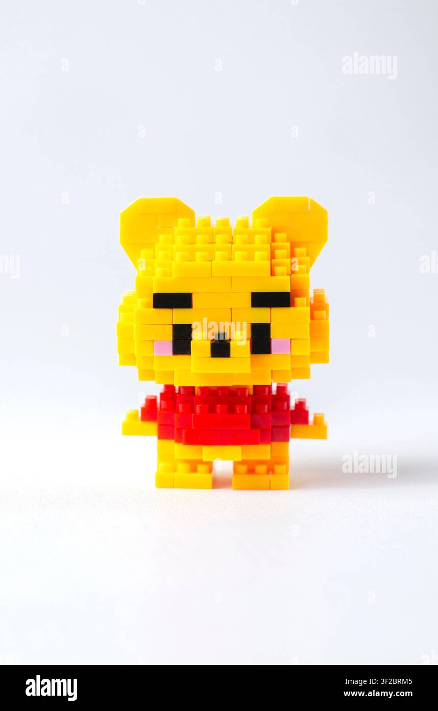 Figure de jouet en forme d'ours en mini bloc jaune isolée sur un fond blanc propre, adaptée pour un jouet de collection, un produit pour enfants, un personnage ludique Banque D'Images