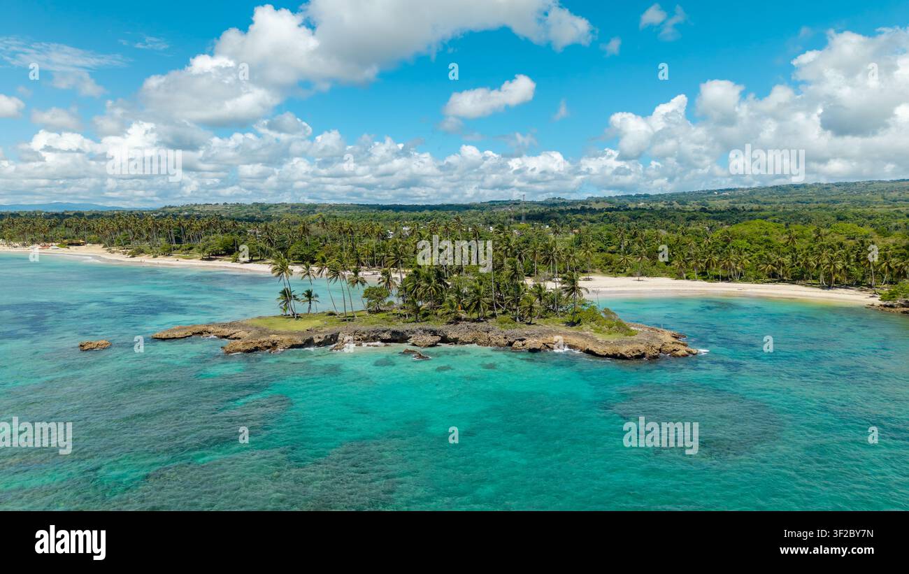 Vue aérienne d'une petite île rocheuse avec des palmiers entourée d'eaux turquoise des Caraïbes à Cabrera. Cabrera, María Trinidad Sánchez, République dominicaine Banque D'Images