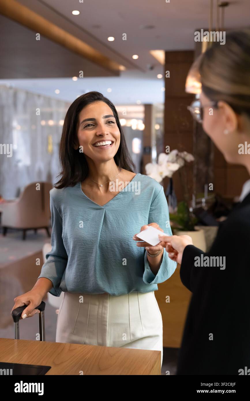 Client d'hôtel recevant une carte-clé au comptoir de réception Banque D'Images
