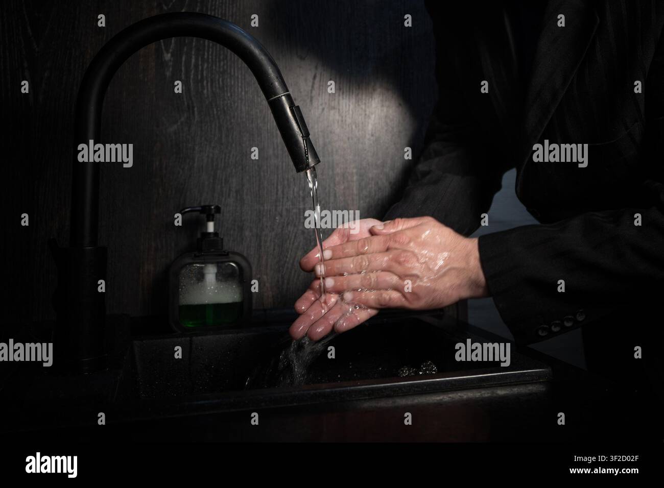 Un homme se lave les mains au-dessus du lavabo dans le bureau Banque D'Images