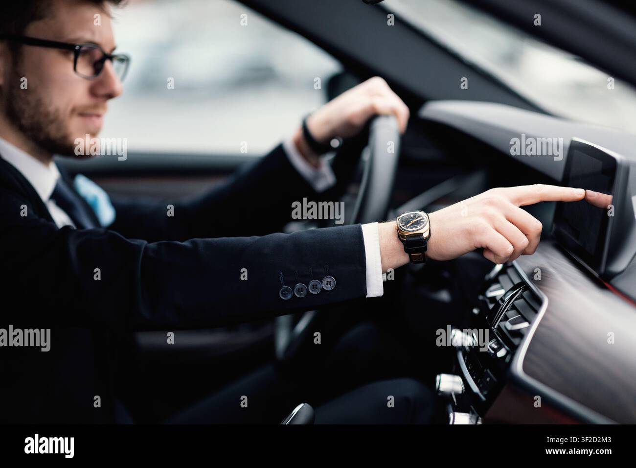 Homme en lunettes assis dans son tableau de bord de vérification automatique Banque D'Images
